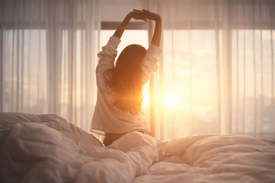Morning sunlight wake-up routine with stretching, representing natural cortisol rhythm and peak morning energy